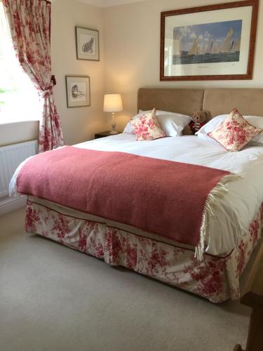 1 dormitorio con 1 cama grande con manta roja en Tirol House en Thakeham