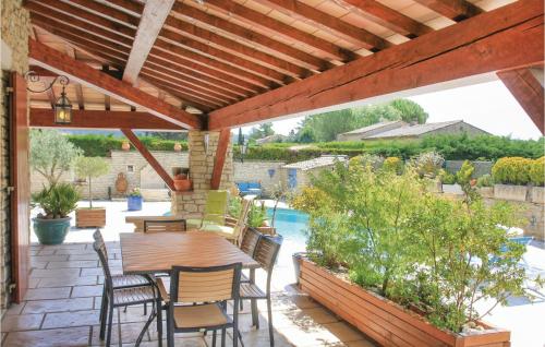 un patio avec une table et des chaises sous une pergola en bois dans l'établissement 3 Bedroom Stunning Home In Gordes, à Gordes