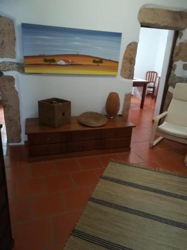 a living room with a table and a painting on the wall at Casa do Ferreiro in Tolosa