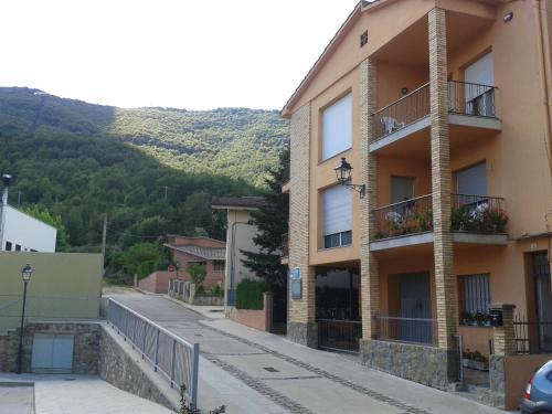 a building on a street with a mountain in the background at Fonda Finet in Sant Felíu de Pallarols