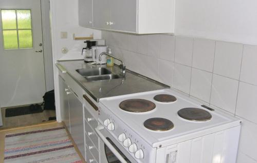a kitchen with a white stove and a sink at Holiday Home Håknehult Lidhult in Lidhult