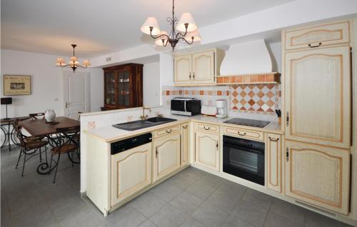 une cuisine avec des armoires en bois et une table à l'intérieur dans l'établissement Amazing Home In Roquebrune Sur Argens, à Roquebrune-sur Argens