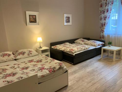 um quarto com 2 camas e uma mesa com um candeeiro em Apartament Romantic em Oświecim