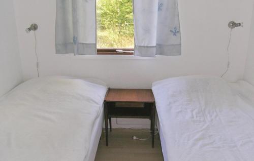 LidhultにあるBeautiful Home In Lidhult With 2 Bedroomsのデスク、窓が備わるドミトリールームのベッド2台分です。