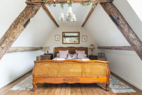 ein Schlafzimmer mit einem großen Bett im Dachgeschoss in der Unterkunft Tudor Cottage in Fairford