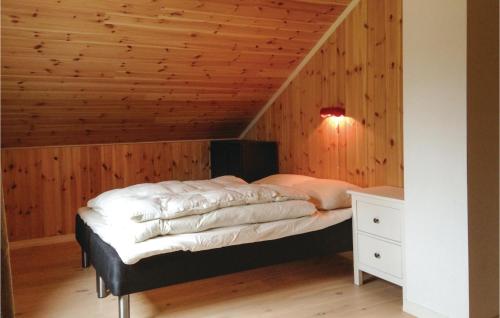 uma cama num quarto com tecto em madeira em Amazing Home In Seim With House Sea View em Seim