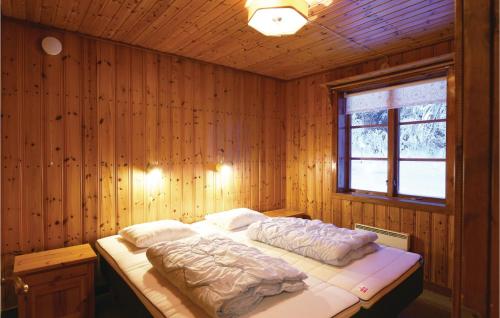 ein Schlafzimmer mit einem Bett in einer Holzwand in der Unterkunft 2 Bedroom Stunning Home In Sysslebck in Sysslebäck