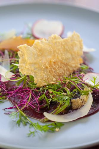 a white plate of food with vegetables on it at Cradle Boutique Hotel in Lanseria