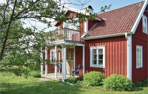 a red house with a porch and a chair at Lovely Home In Virserum With Wifi in Virserum