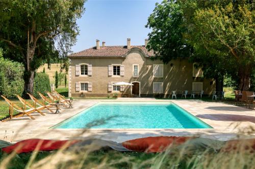 une piscine devant une maison dans l'établissement Le Château de Camille, à Saint-Jean-le-Comtal