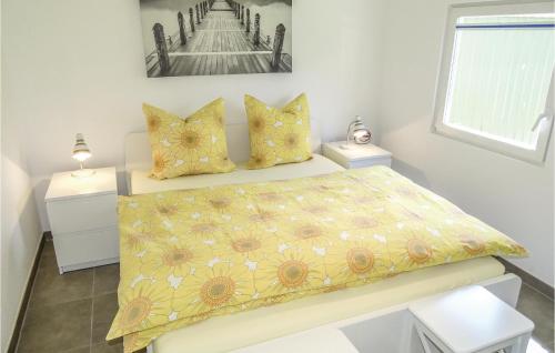 ein Schlafzimmer mit einem Bett mit gelber Bettdecke und Kissen in der Unterkunft Lovely Home In Insel Poel With Kitchen in Insel Poel