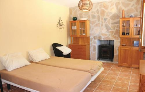 JijonaにあるBeautiful Home In Jijona With 3 Bedrooms, Wifi And Private Swimming Poolのベッドルーム1室(ベッド2台、暖炉付)