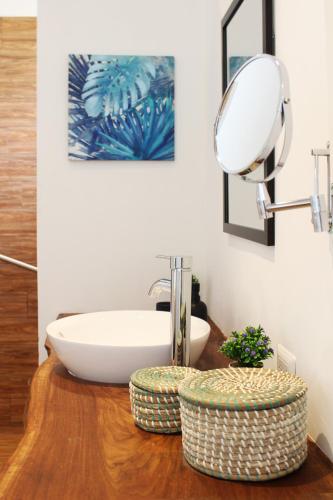 a bathroom with a sink and a mirror on a table at Ojochal Gardens in Ojochal