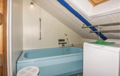 uma casa de banho com uma banheira azul num quarto em 3 Bedroom Amazing Home In lgars em Älgarås