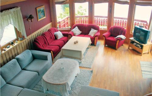 a living room with red couches and a tv at Amazing Home In Farsund With House Sea View in Lindland