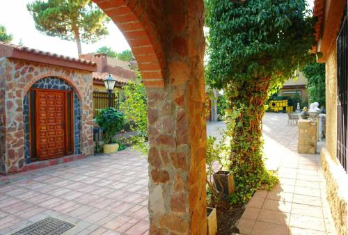 a stone building with a door and a brick walkway at Hotel Rural Don Quijote in Cuenca