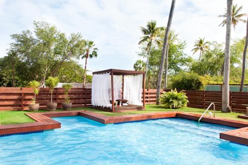 a swimming pool with a gazebo next to a house at Villa Montaña Beach Resort in Isabela