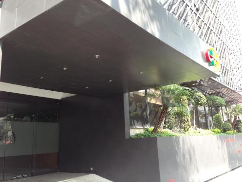 a black building with a palm tree in front of it at Hotel Amazonas in Mexico City