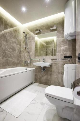 a bathroom with a sink and a toilet and a bath tub at Allurapart Plaza in Kyiv