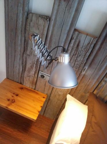 a lamp on a wall next to a bed at Las Coles Apartasuites in Xàtiva