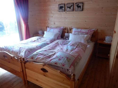 a bedroom with a bed in a log cabin at KRETZSCHMAR´S HÜTTE in Hochrindl