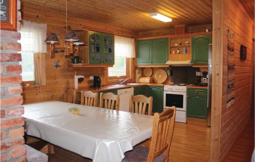a kitchen with green cabinets and a white table at Amazing Home In Farsund With House Sea View in Lindland