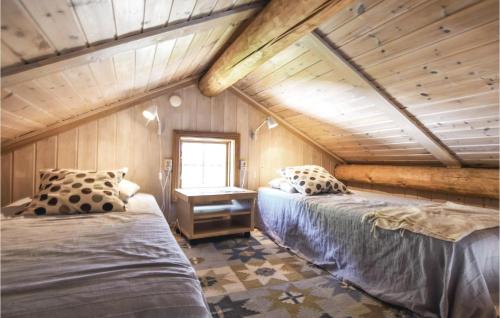 a attic bedroom with two beds and a desk at Cozy Apartment In Sysslebck With Sauna in Sysslebäck