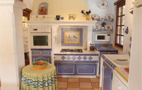 - une cuisine bleue et blanche avec cuisinière dans l'établissement 3 Bedroom Stunning Home In Gordes, à Gordes