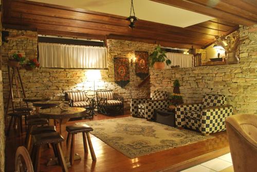 a bar with chairs and tables and a stone wall at Hotel Pousada do Arcanjo in Ouro Preto