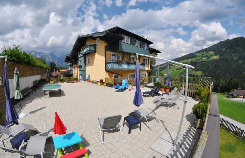 a house with a patio with chairs and umbrellas at Apparthotel Bliem in Schladming