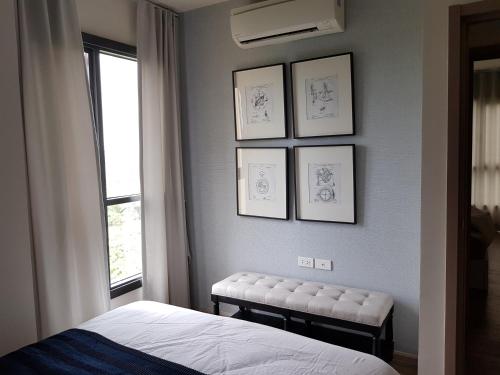 - une chambre avec un lit et des dessins encadrés sur le mur dans l'établissement Rain Cha-am Huahin by Smiley, à Cha Am