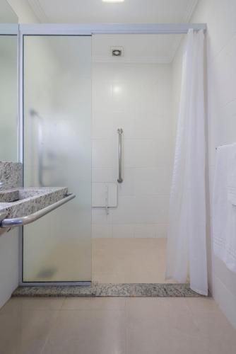 a shower with a glass door in a bathroom at Hotel Glória Blumenau in Blumenau