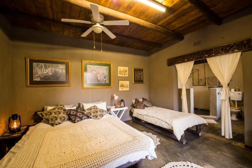a bedroom with two beds and a ceiling fan at Rio Dos Elefantes River Camp in Hoedspruit