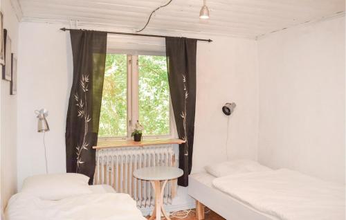 een kamer met 2 bedden en een raam bij Awesome Home In Ljungby With Kitchen in Bolmen