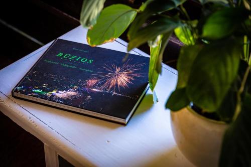 a book sitting on a table next to a potted plant at Morada do Sol Guest House in Búzios