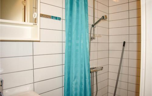 a shower with a blue shower curtain in a bathroom at Nice Home In Hllviken With 2 Bedrooms in Höllviken