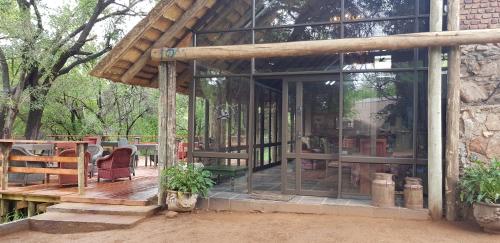 a house with glass doors and a wooden deck at Rio Dos Elefantes River Camp in Hoedspruit