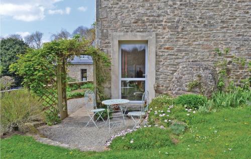 une table et des chaises devant un bâtiment en pierre dans l'établissement Stunning Home In Plogastel St Germain, à Plogastel-Saint-Germain
