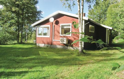 a small red house in a field of grass at Holiday Home Håknehult Lidhult in Lidhult