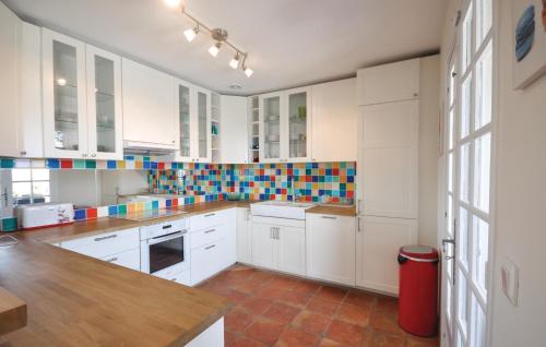 une cuisine avec des armoires blanches et une poubelle rouge dans l'établissement Cozy Home In Les Issambres, aux Issambres