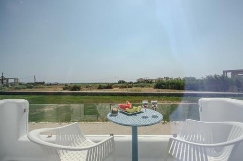 a table with chairs and a bowl of fruit on it at Naxos Island Escape Suites in Plaka