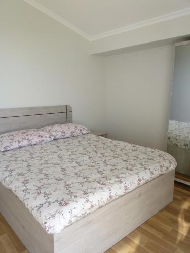 a bedroom with a bed with a floral bedspread at Iberia 2019 in Batumi