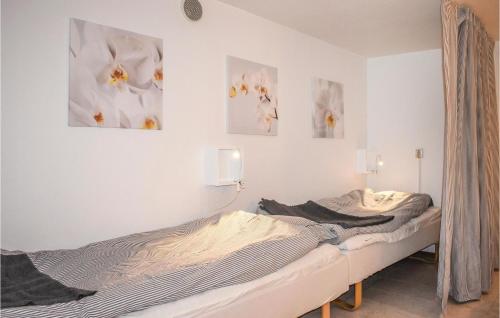 ヘルヴィーケンにあるCozy Home In Hllviken With Wifiの壁に写真2枚が飾られた客室内のベッド2台
