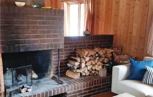 a brick fireplace with a pile of fire wood at Four-Bedroom Holiday Home In Killeberg in Killeberg