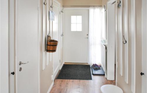 einen Flur mit einer weißen Tür und einem schwarzen Teppich in der Unterkunft Cozy Home In motsfors With Kitchen in Gryttved