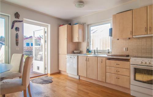 ヴィスビーにあるStunning Home In Visby With 3 Bedrooms And Wifiのキッチン(木製キャビネット、テーブル、窓付)