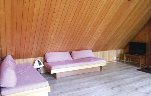 a room with a bed and a tv in a wooden ceiling at Four-Bedroom Holiday Home In Killeberg in Killeberg
