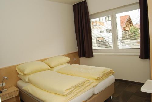a room with a bed with pillows and a window at Haus Schraberger in Schladming