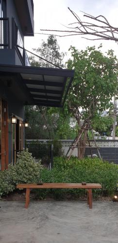 a wooden bench sitting in front of a building at The Lantern Suites in Ban Song Hong