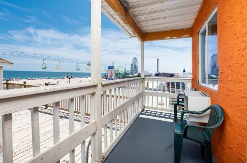 a balcony with a chair and a view of the beach at Boardwalk Hotel Charlee & Apartments Beach Hotel Oceanfront in Seaside Heights